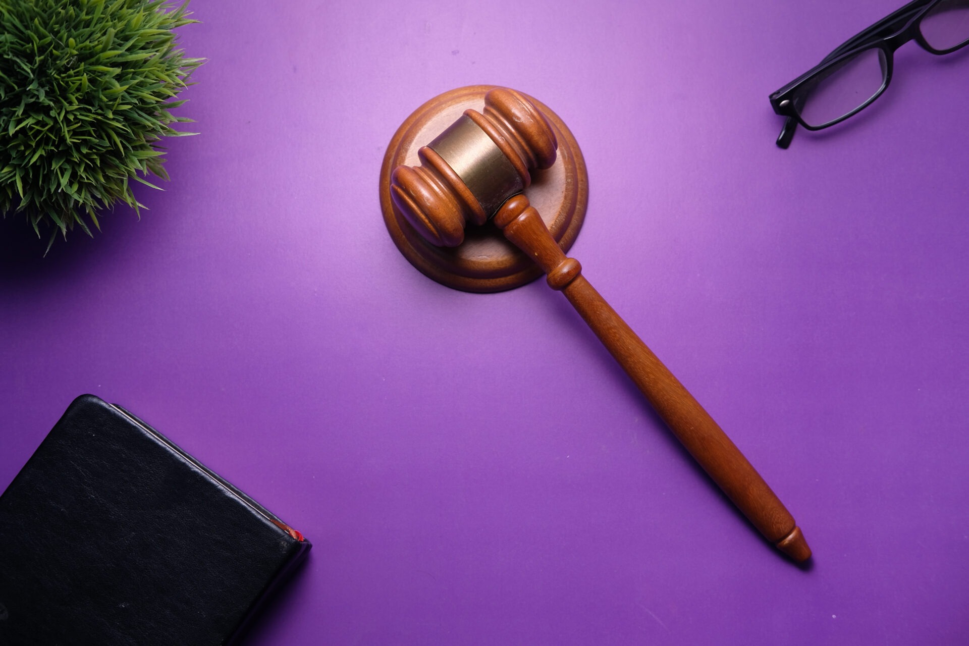 Maillet de juge en bois sur un fond violet, symbolisant la réglementation et la cybersécurité dans le cadre de la directive NIS